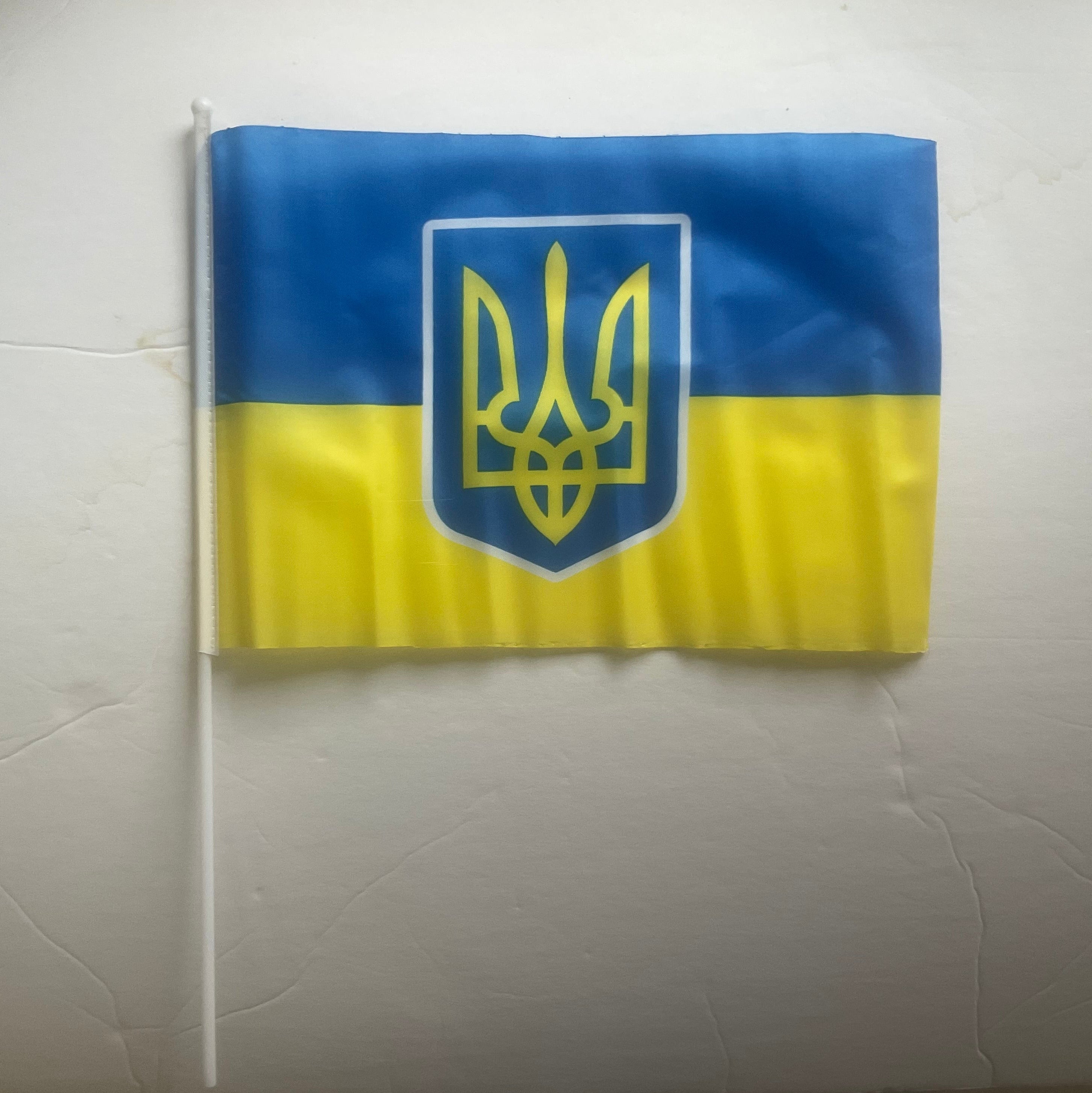 Ukrainian flag on sale with gold Trident â available in 15x20 cm and 20x30 cm sizes, on a plastic stick, made in Ukraine