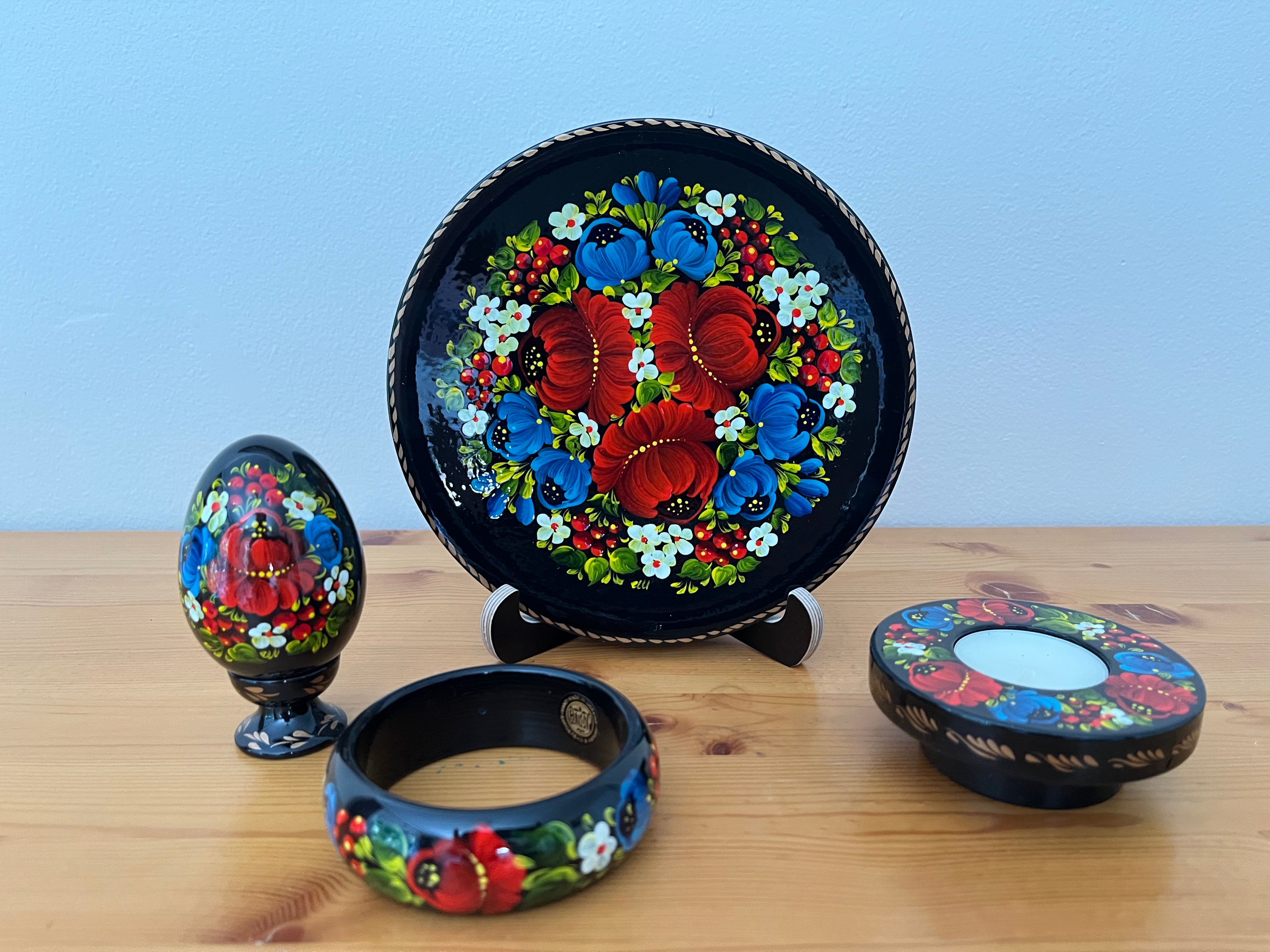 Hand-painted Red Poppies & Blue Flowers Petrykivka collection featuring a decorative plate, wooden pysanka, candle holder, and bracelet handmade in Ukraine