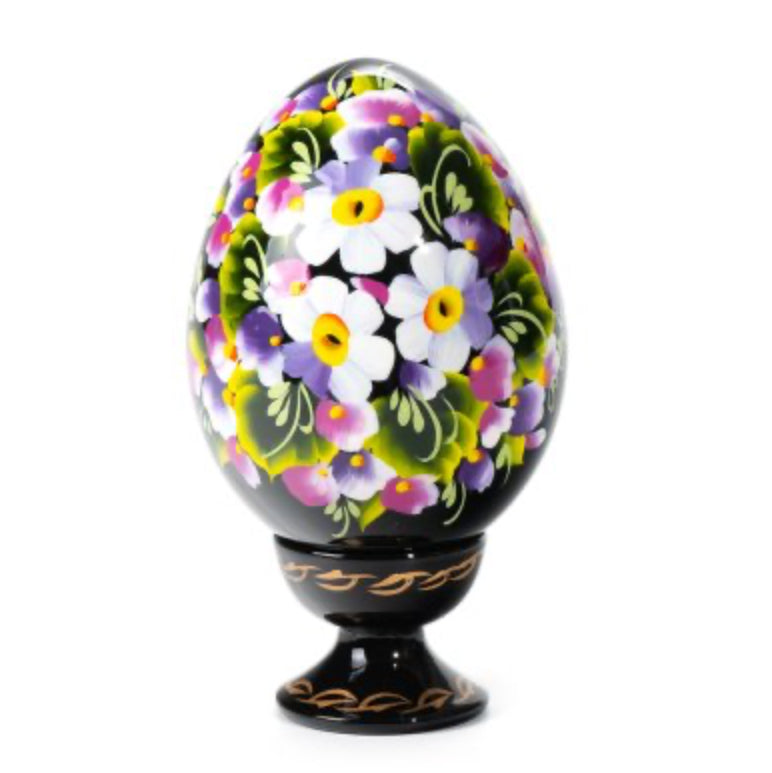 Tenderness wooden Ukrainian pysanka hand-painted with white flowers in the Petrykivka tradition