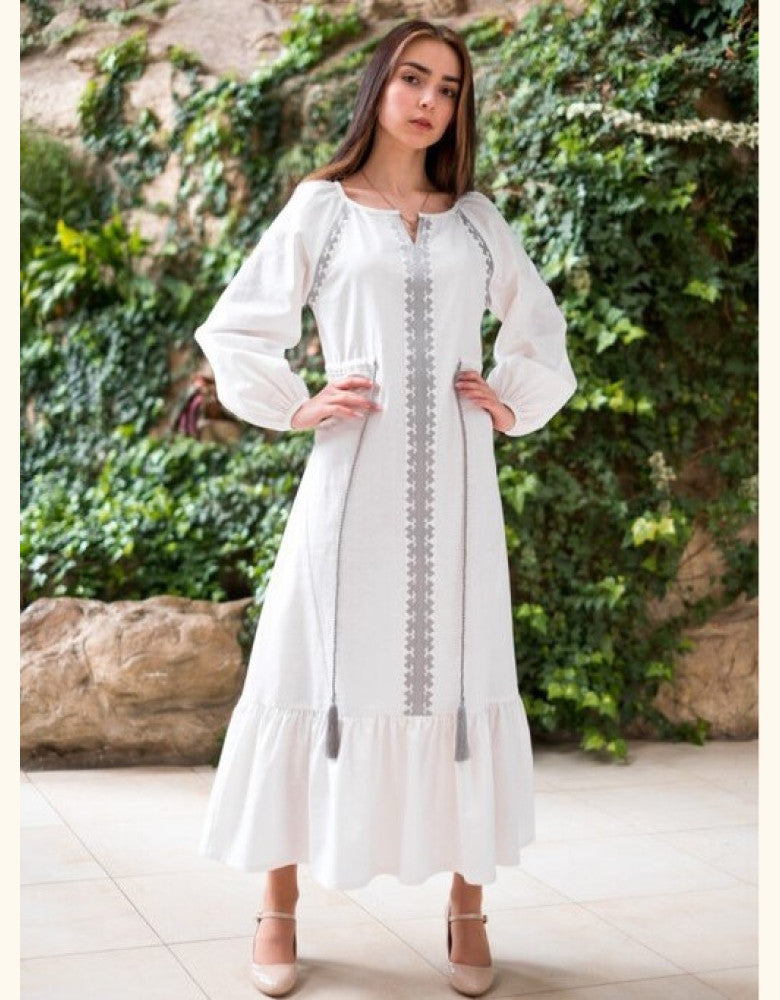 Woman wearing Barvinok white linen vyshyvanka dress with silver embroidery made in Ukraine