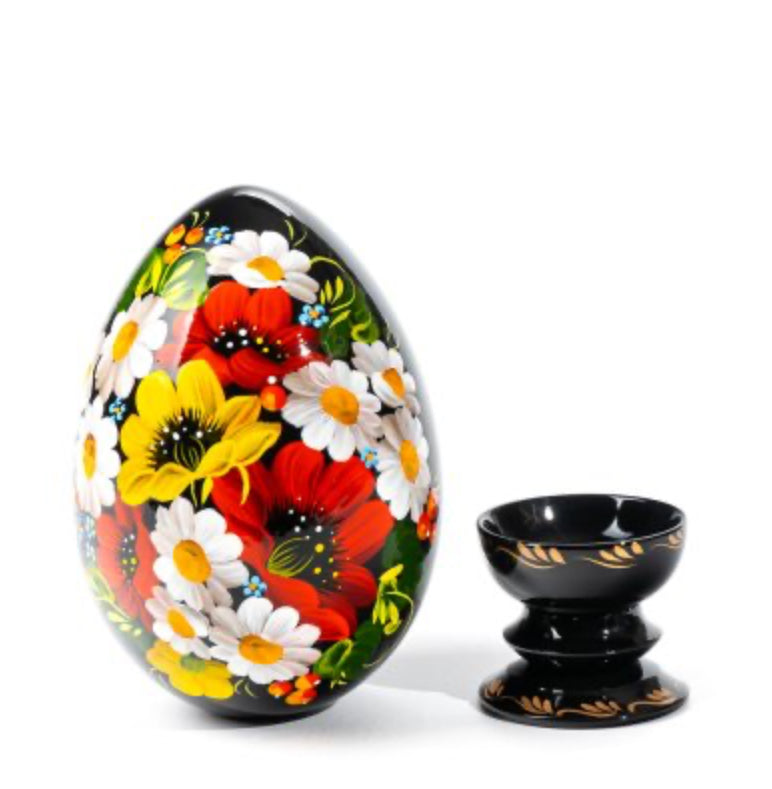 Close-up of hand-painted poppies, daisies, and floral Petrykivka brushwork on a wooden Ukrainian pysanka