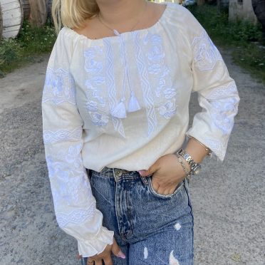 Woman wearing Ulyana linen vyshyvanka with white floral embroidery made in Ukraine